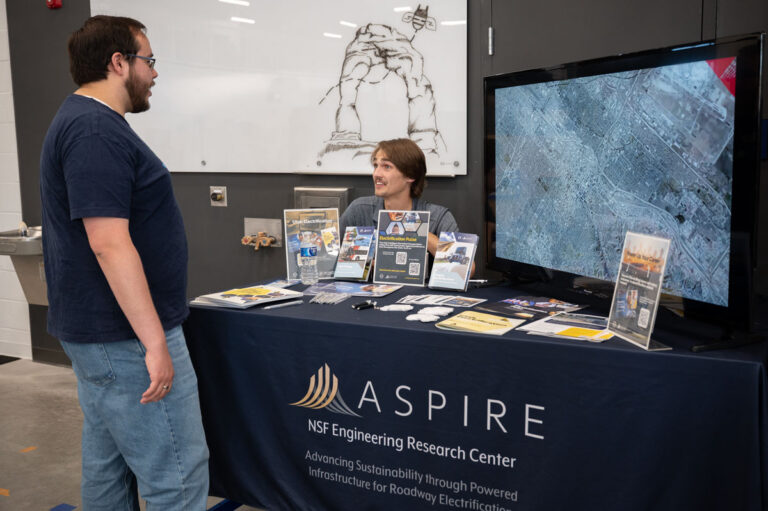 ASPIRE student explains the Utah Electrification Initiative to an Open House guest.