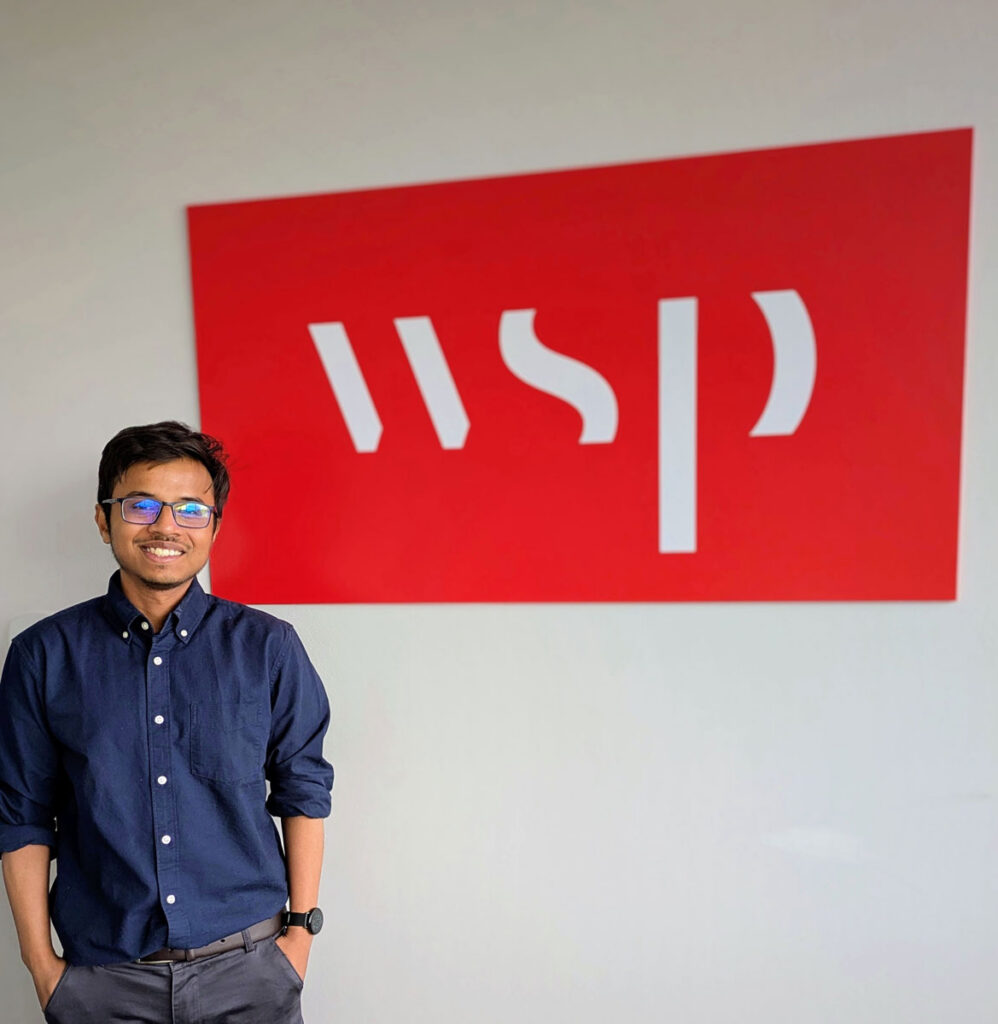Abdullah Al Mehadi smiling next to the WSP sign, where he interned.