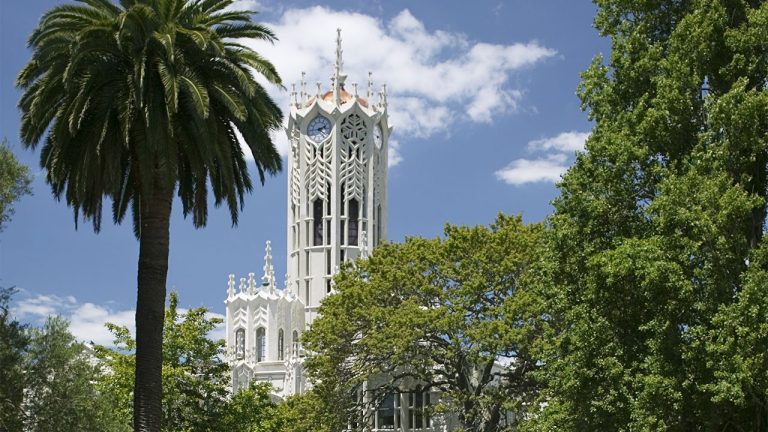 Picture of the University of Auckland with palm trees in front.